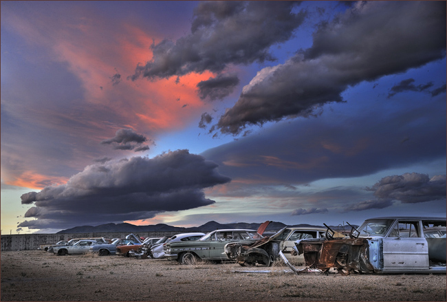 Old cars under a colorful sky