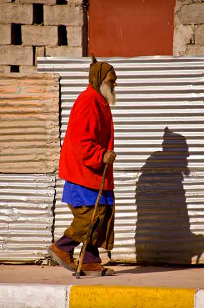 Old bearded man walking in an urban environment