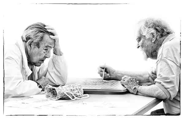 Two senior citizens absorbed in their Scrabble game