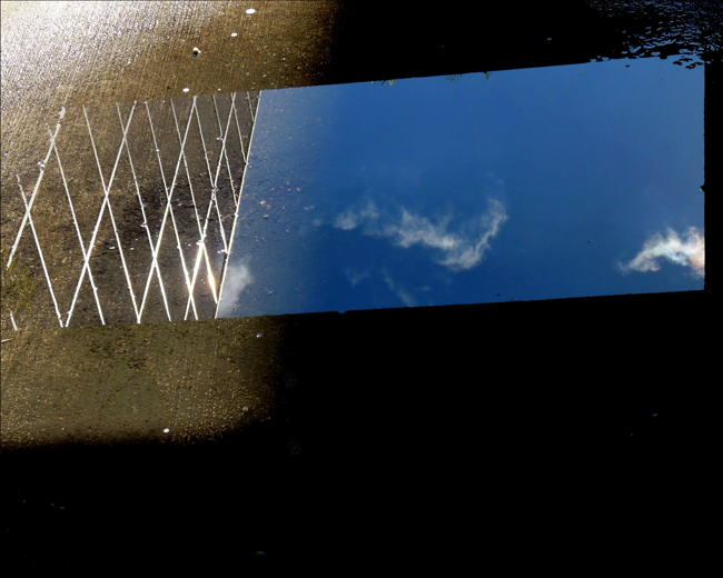 Sky and clouds reflected on a glass on the floor