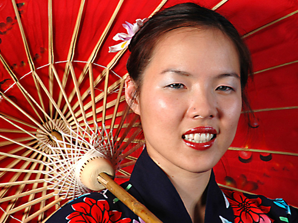 Head shot of oriental lady with red umbrella