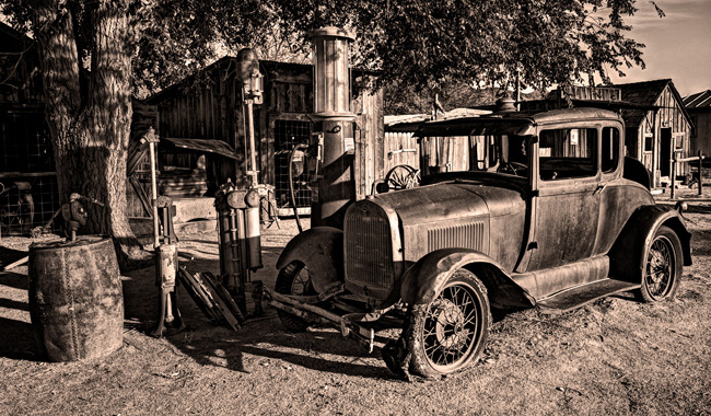 Antique Car in front of derelict gas station