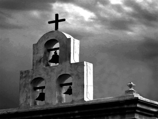 Church bells and cross against the sky