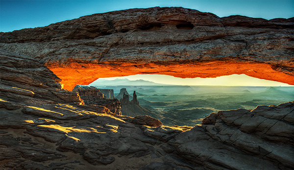 Natural arch with underslide lit by sunrise