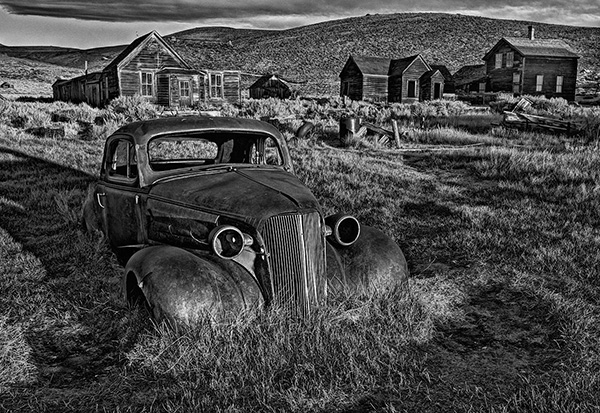 Rusty car with old houses in the background