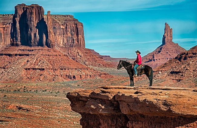 Cowboy on horse overlooking Monument Valley